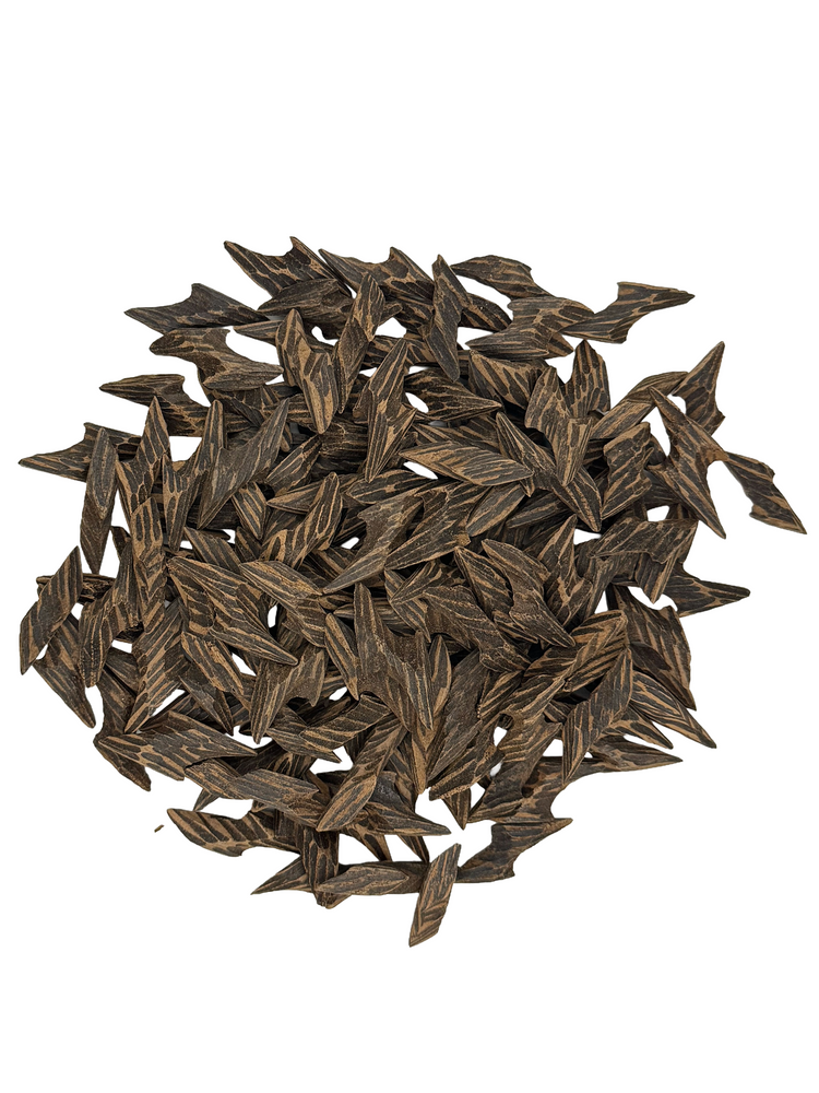 A pile of dark brown, textured arrowhead-shaped beads or charms on a solid white background.