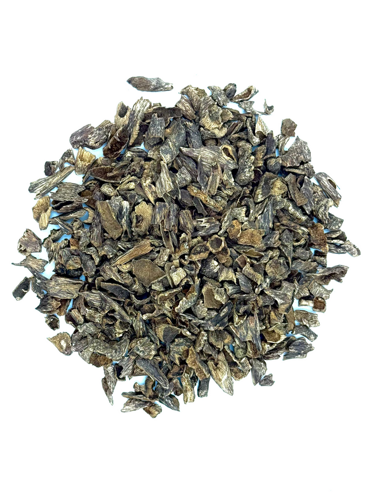 A pile of dried bark or wood shavings in dark brown, gray, and black tones, photographed from directly above on a plain white background.