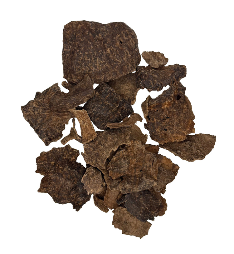 A pile of dark brown dried root or bark pieces with rough, textured surfaces, photographed on a plain white background.